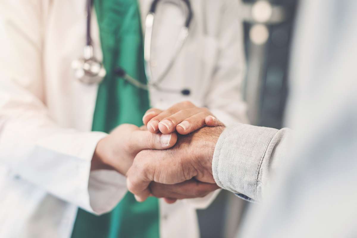 a doctor holds the hand of a patient