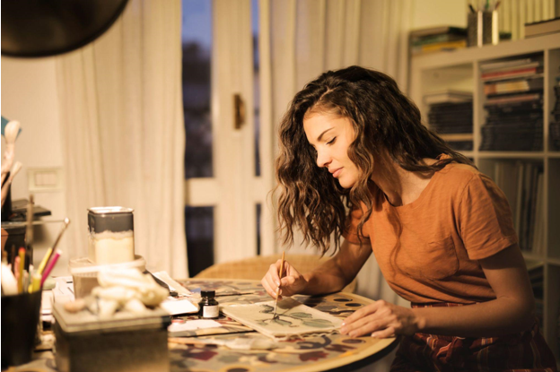 girl sitting at table painting