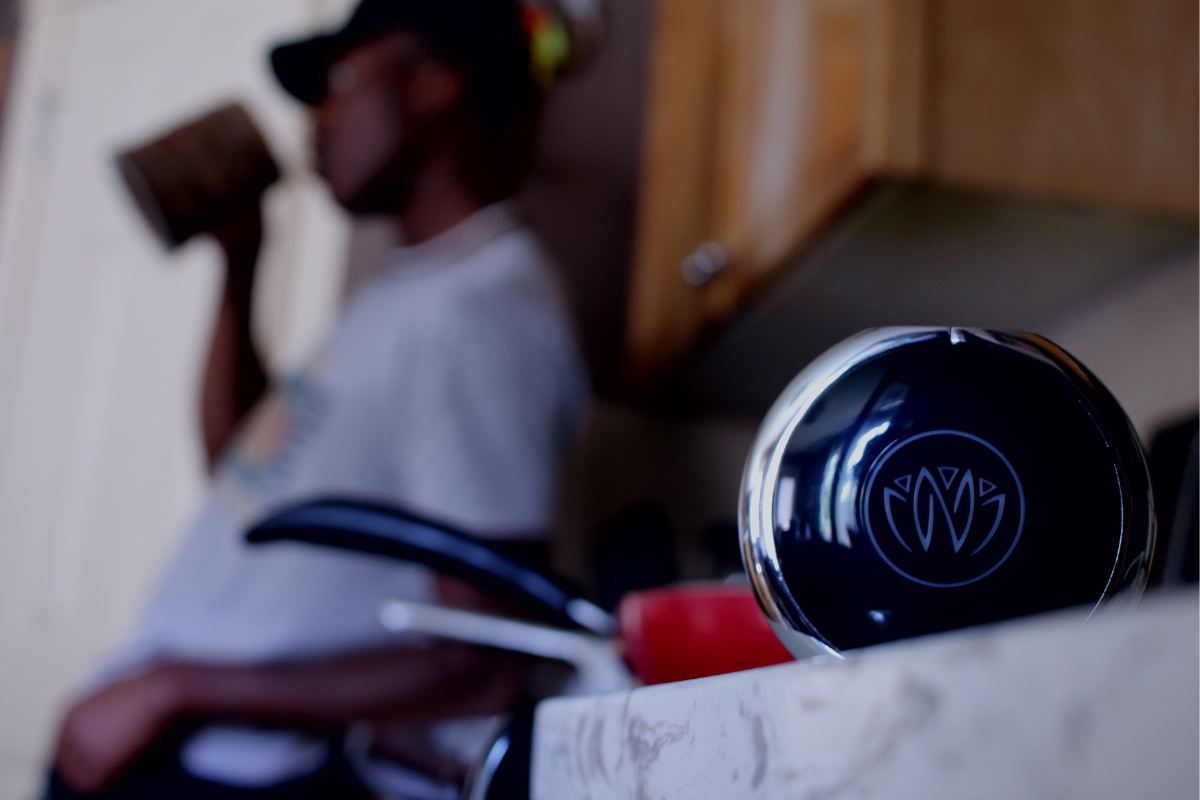 in the background is a man drinking from a coffee cup in the foreground is the xen unit on a countertop