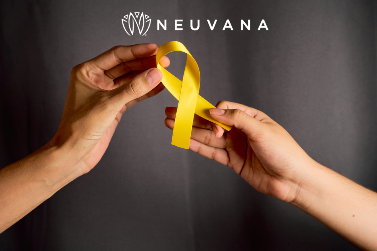 two hands holding a yellow awareness ribbon