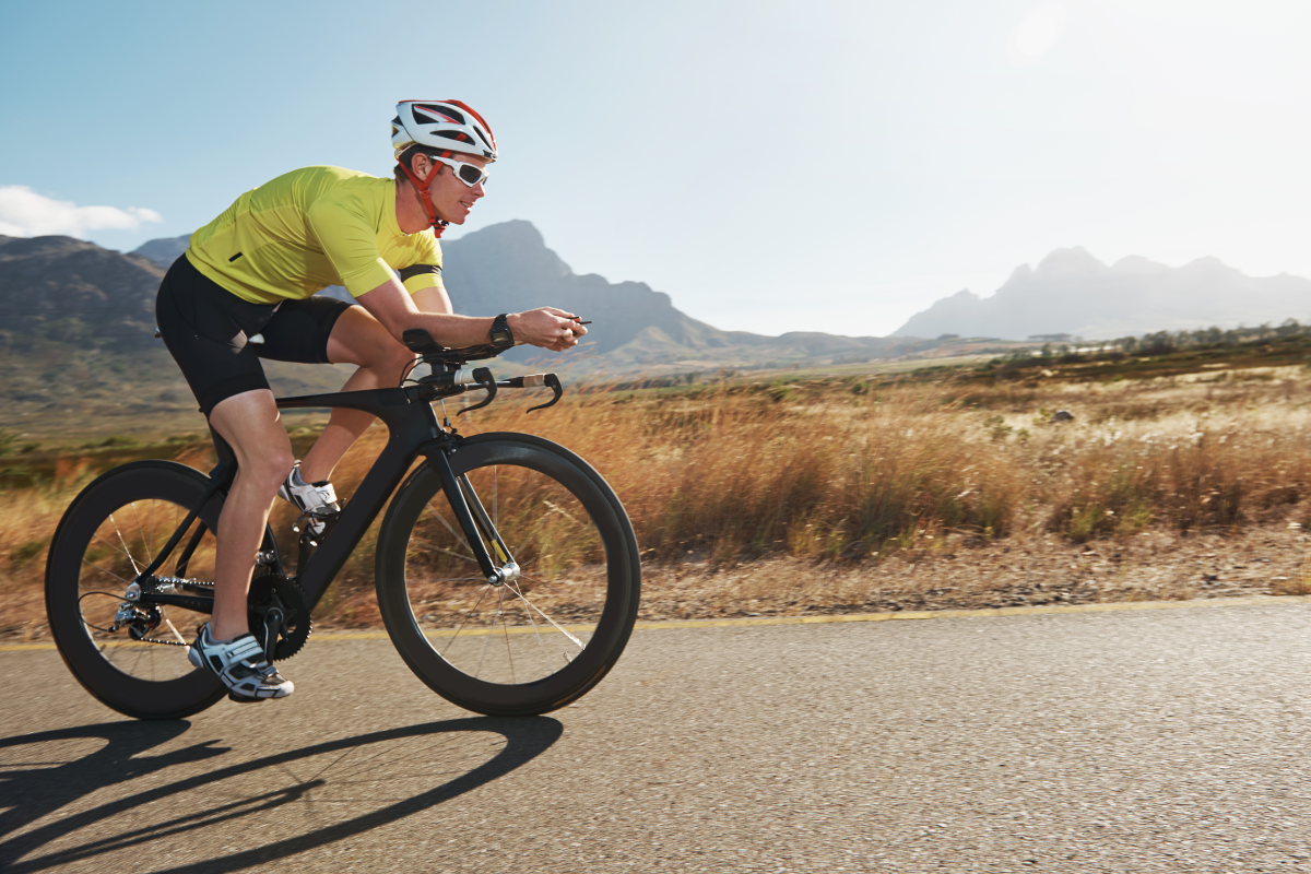 a professional bicyclist is riding their bike in front of a mountain range