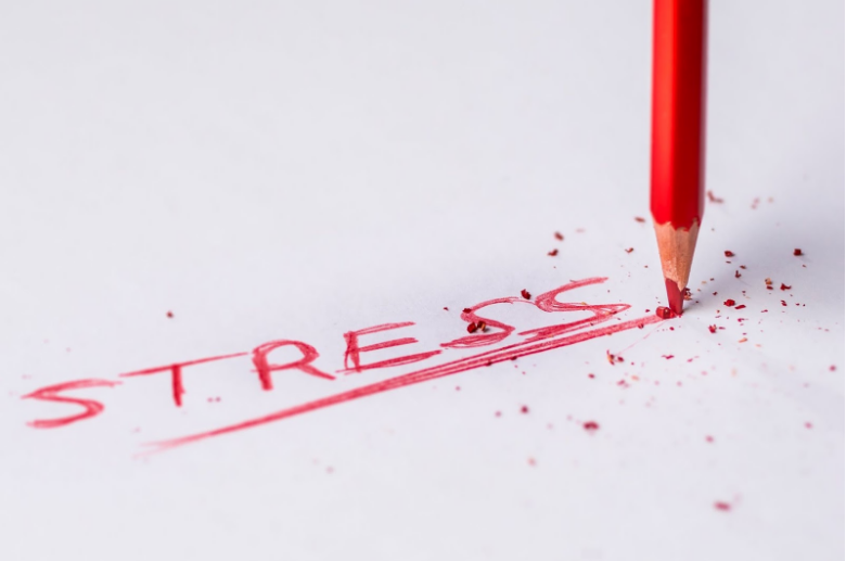writing the word stress in red colored pencil