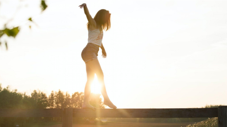 girl walking on fence